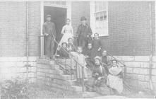 SA0205 - Adults & children--William Kennedy, William Rochester, Cynthia Shain, Sarah Pennybaker--on the steps of a brick building. Identified on the back., Winterthur Shaker Photograph and Post Card Collection 1851 to 1921c